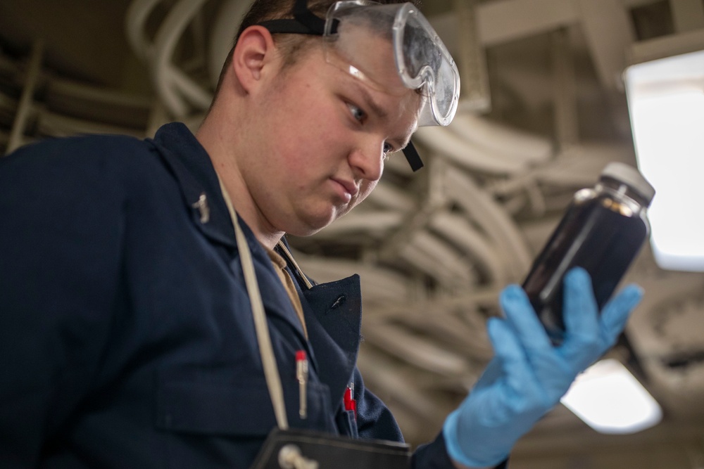 USS Tripoli Sailor Inspects oil
