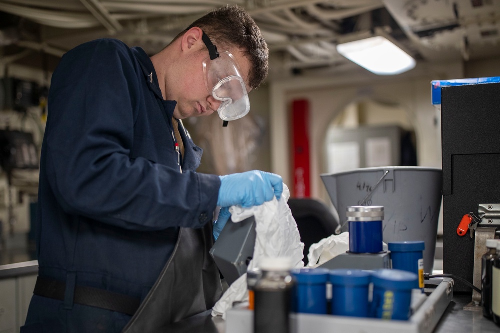 USS Tripoli Sailor Inspects oil