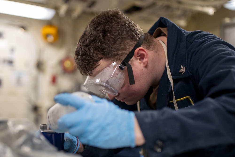 USS Tripoli Sailor Inspects oil