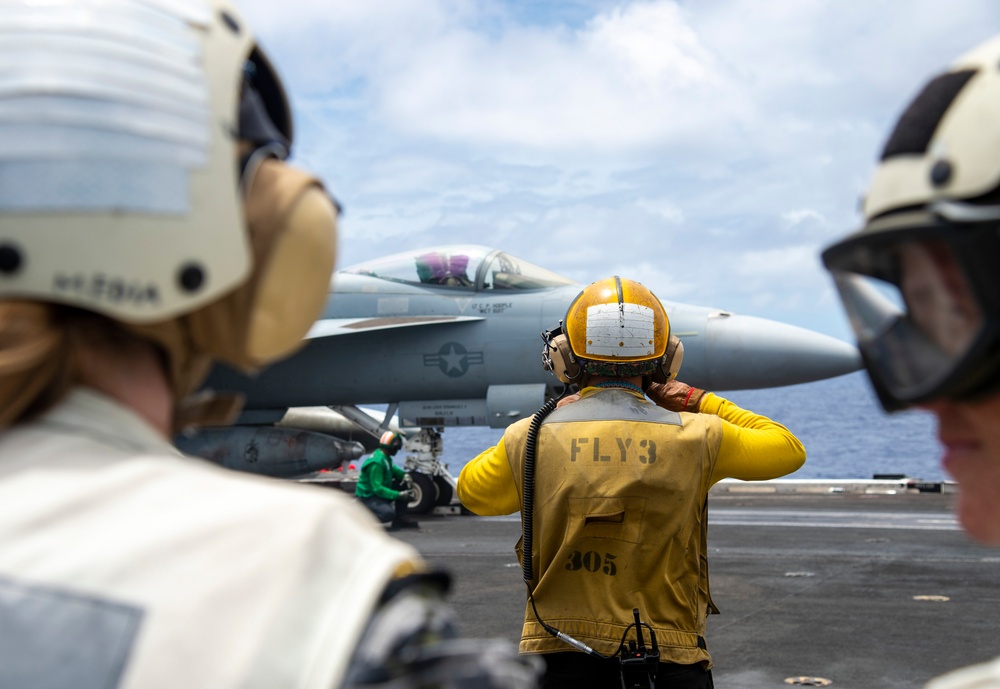 Members of the Royal Australian Navy watch flight operations aboard Nimitz-class aircraft carrier USS Carl Vinson (CVN 70) .