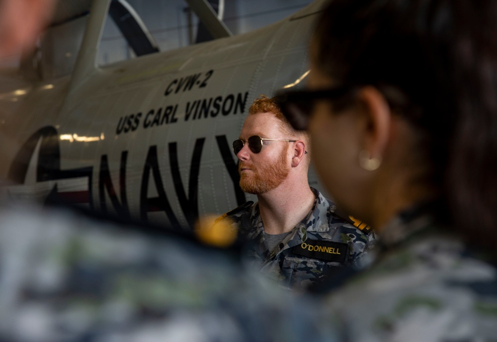Royal Australian Navy Lt. Cal O’Donnell tours the hangar bay aboard Nimitz-class aircraft carrier USS Carl Vinson (CVN 70).