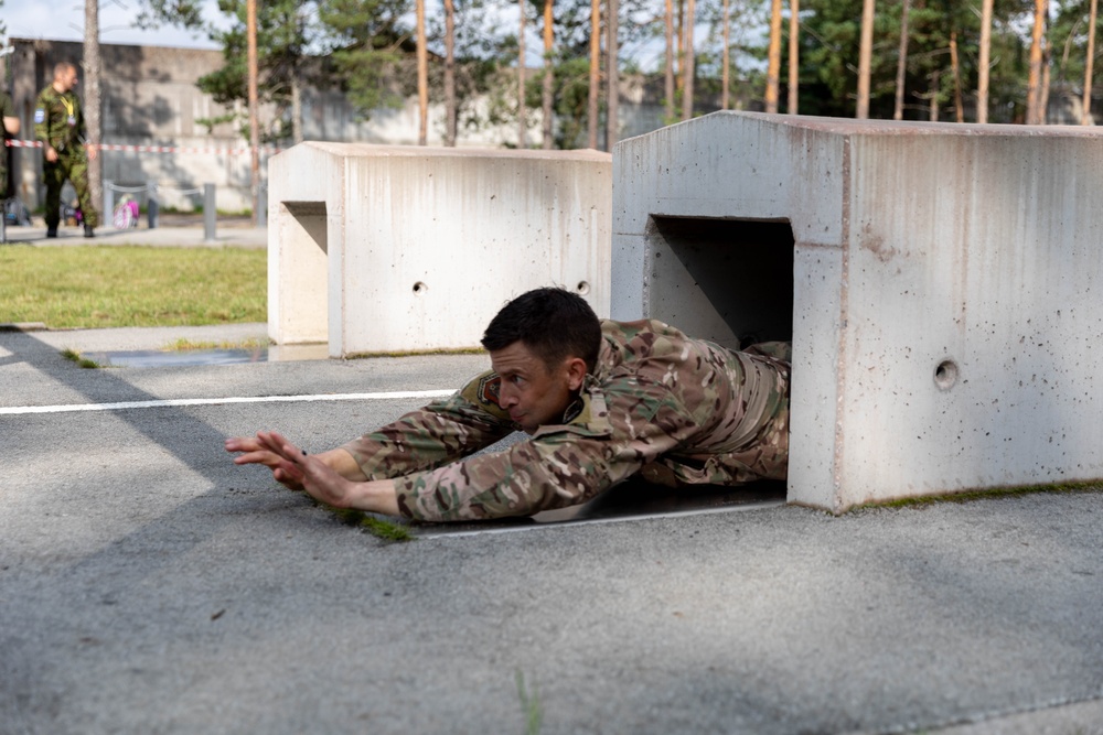 Maj. Sterling Broadhead dives through an obstacle