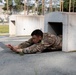 Maj. Sterling Broadhead dives through an obstacle