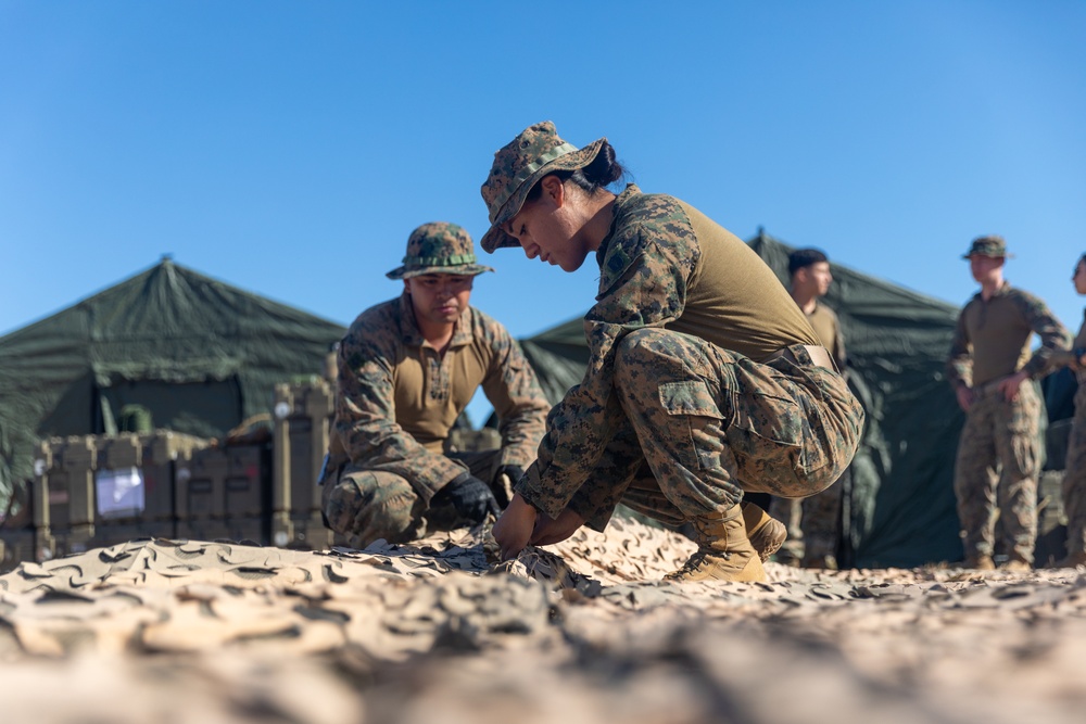 MRF-D 24.3: CLB-5 (Rein.) Sailors apply camouflage netting to a role 2 field hospital