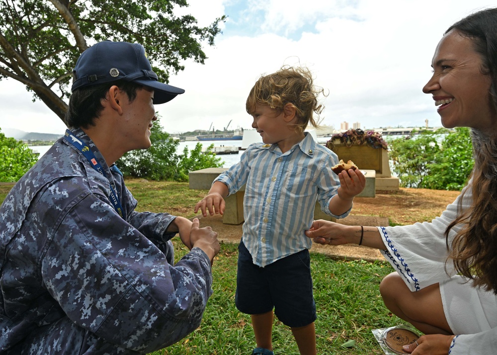 A member of the JMSDF are interacted with the children