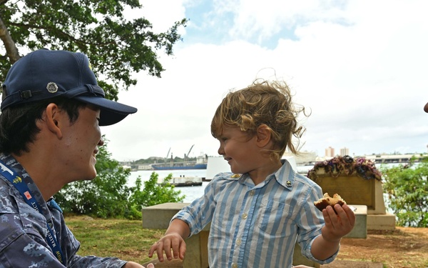 A member of the JMSDF are interacted with the children
