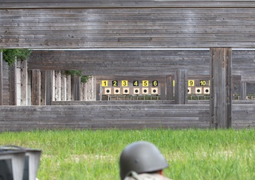 Sgt. 1st Class Benjamin Latham aims down the sights of a LMT R-20 Rahe rifle