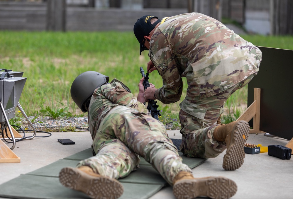 Sgt. 1st Class Kristoffer Friend assists team USA in adjusting their weapons