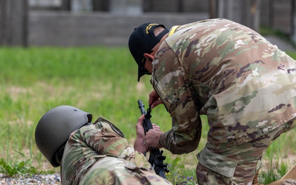 Sgt. 1st Class Kristoffer Friend assists team USA in adjusting their weapons