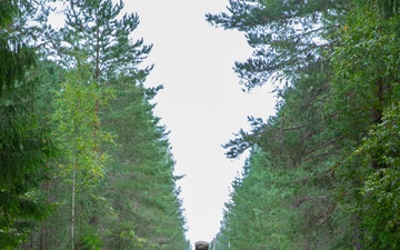 Service members negotiate terrain during a land navigation competition