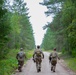 Service members negotiate terrain during a land navigation competition
