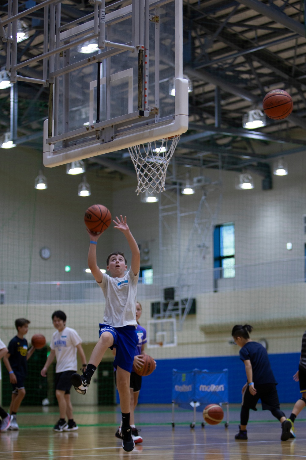 Coaches from Basketball Japan Academy coach children at the Youth Sports Summer Basketball Camp