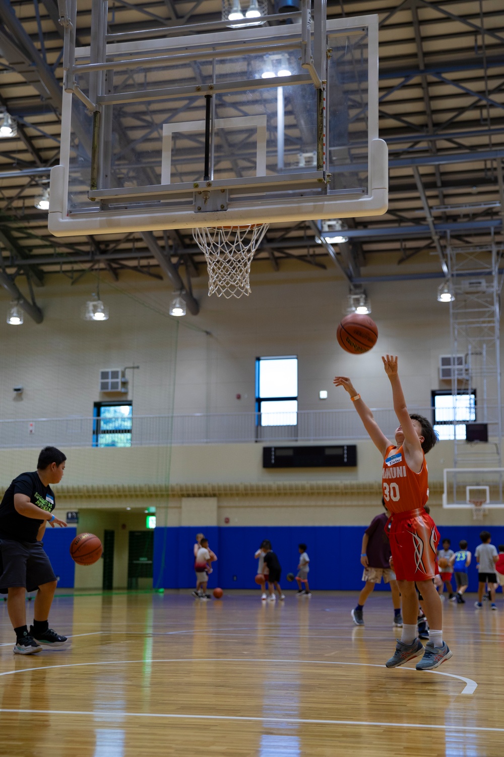 Coaches from Basketball Japan Academy coach children at the Youth Sports Summer Basketball Camp