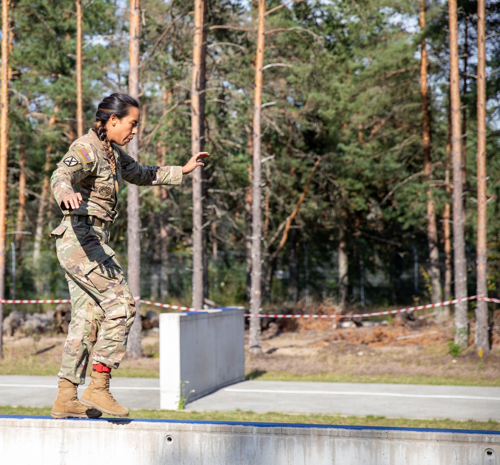 1st Lt. Jessica Romero walks over a concrete obstacle