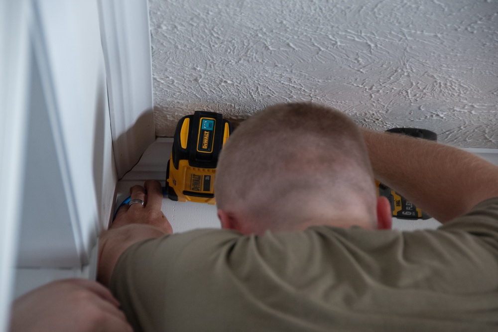 U.S. Air Force Staff Sgt. Braydon Dotson assists fellow service members in a rewiring project for the Blackfeet Tribal Health IT department