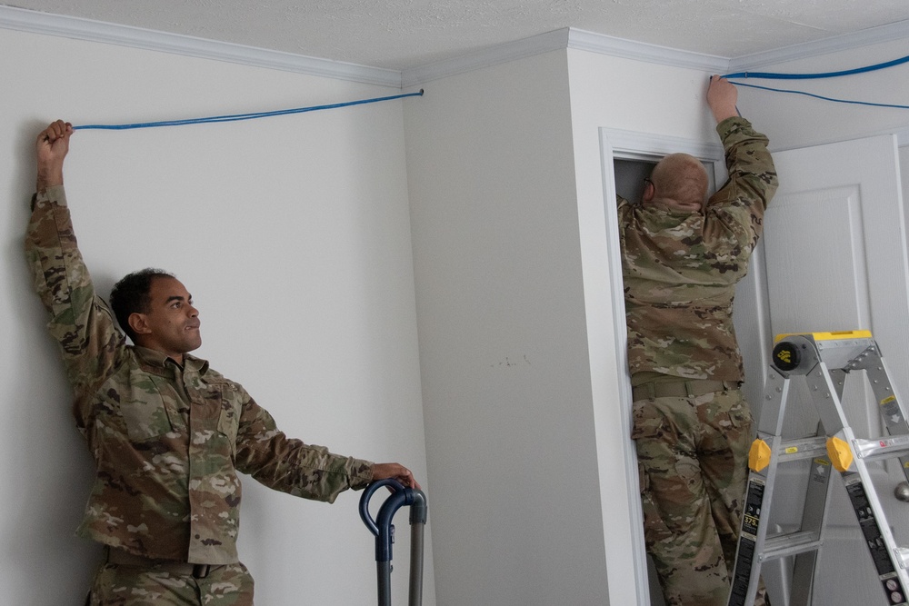 U.S. Air Force SrA Nathan Cotrill and Alexi Rickman assist with a rewiring project at a new Blackfeet Tribal Health IT building