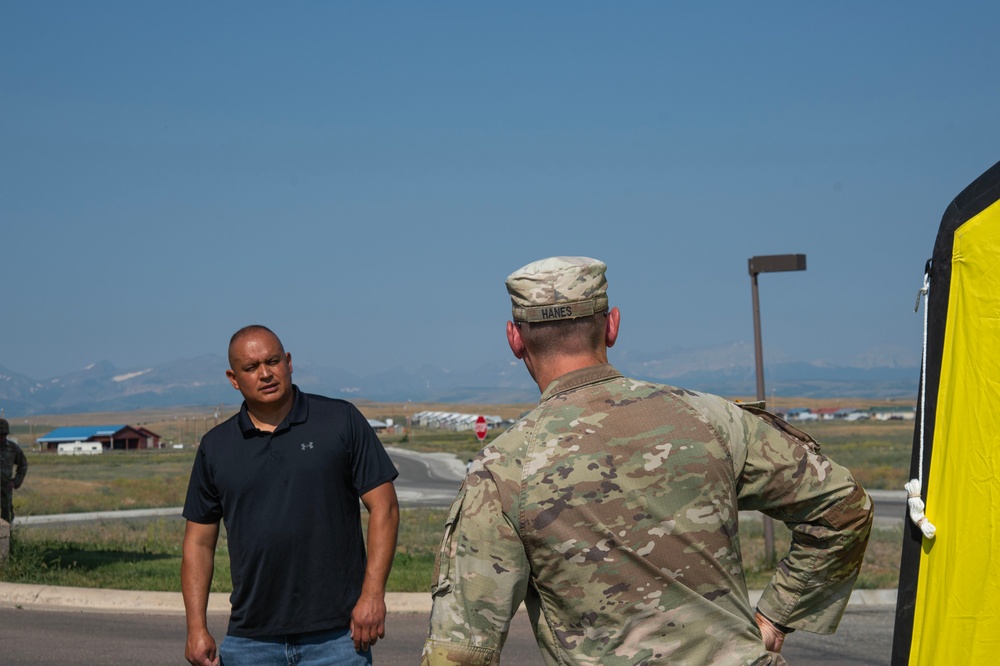 U.S. Army Capt. James Hanes and Mr. Lee Calf Looking set up a mass casualty simulation decontamination tent on Blackfeet Indian Reservation