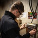 A Nimitz Sailor Grinds Etchings From A Wrench