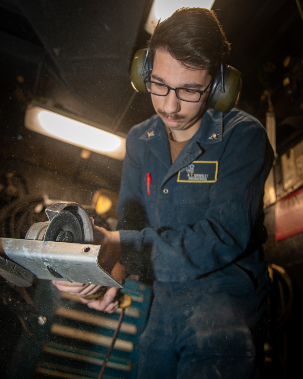 A Nimitz Sailor Grinds Sheet Metal