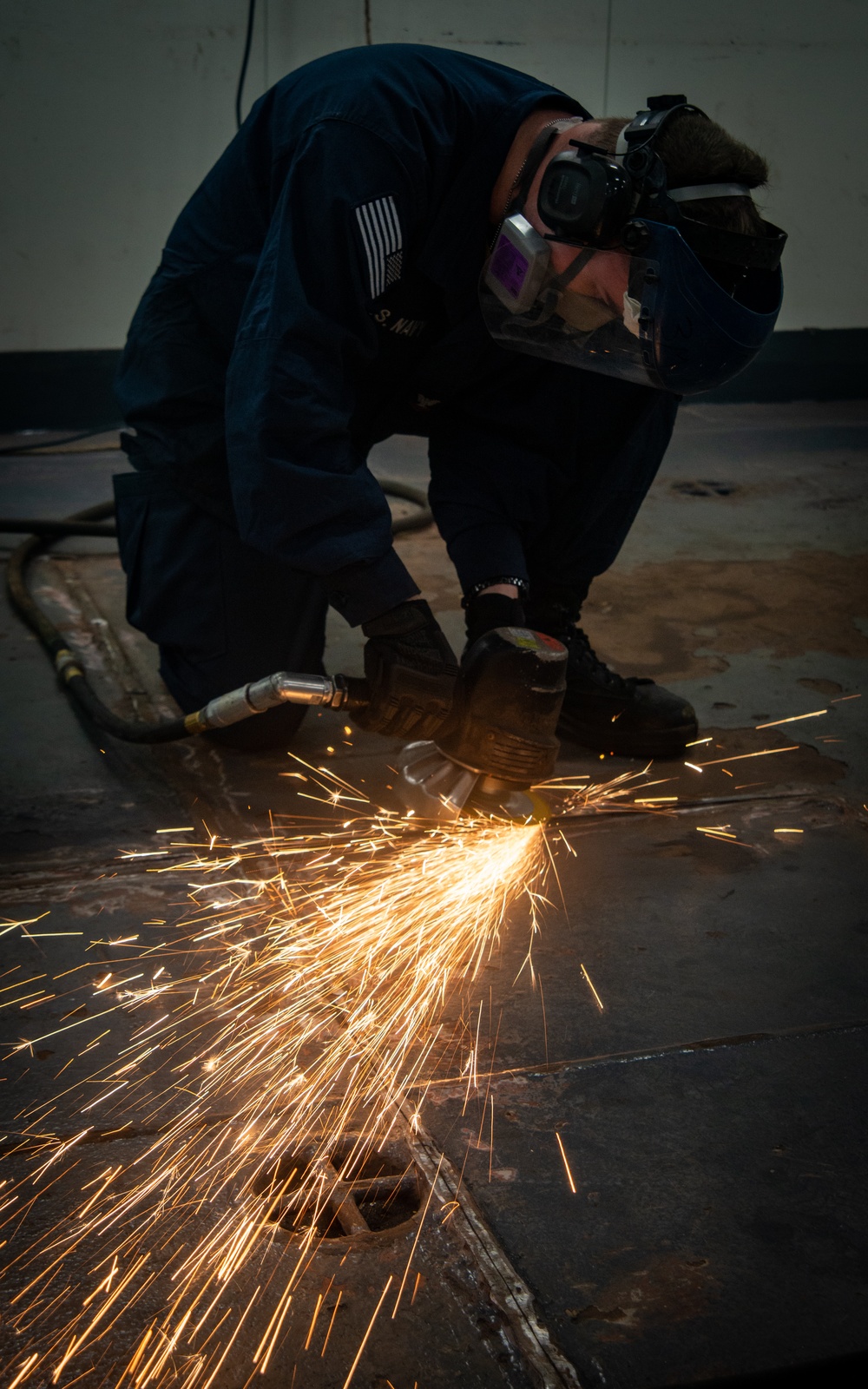 A Nimitz Sailor Grinds Metal From The Deckplates