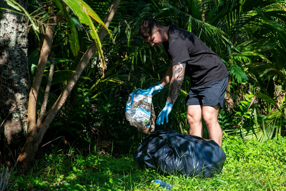 Sailors participate in a volunteer beach clean-up