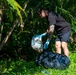 Sailors participate in a volunteer beach clean-up