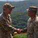 1st Armored Brigade Combat Team command team presents coins to service members during Operation Pacific Fortitude