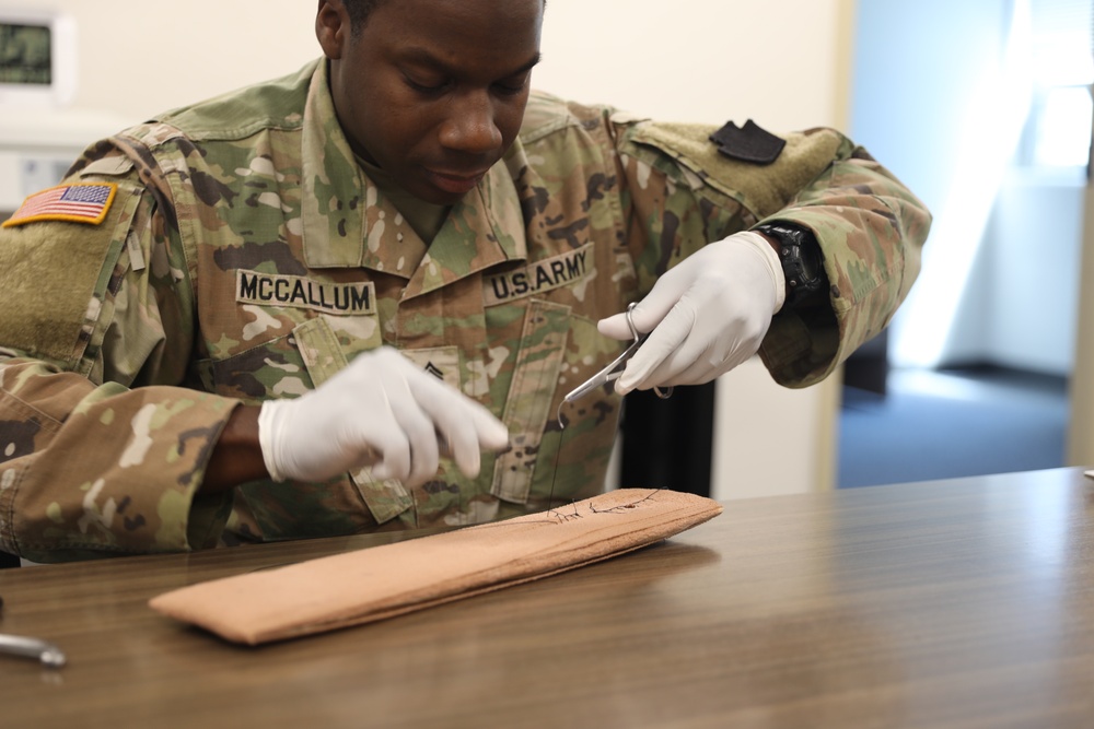 Army medic practices suturing