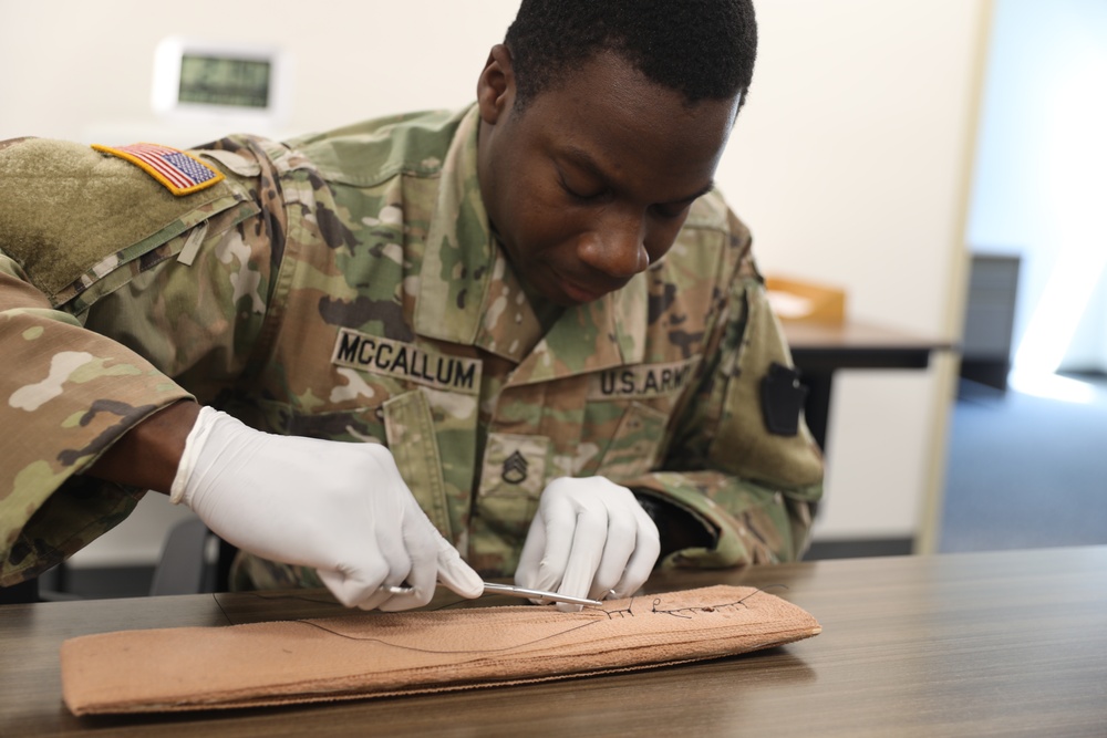 Army medic practices suturing