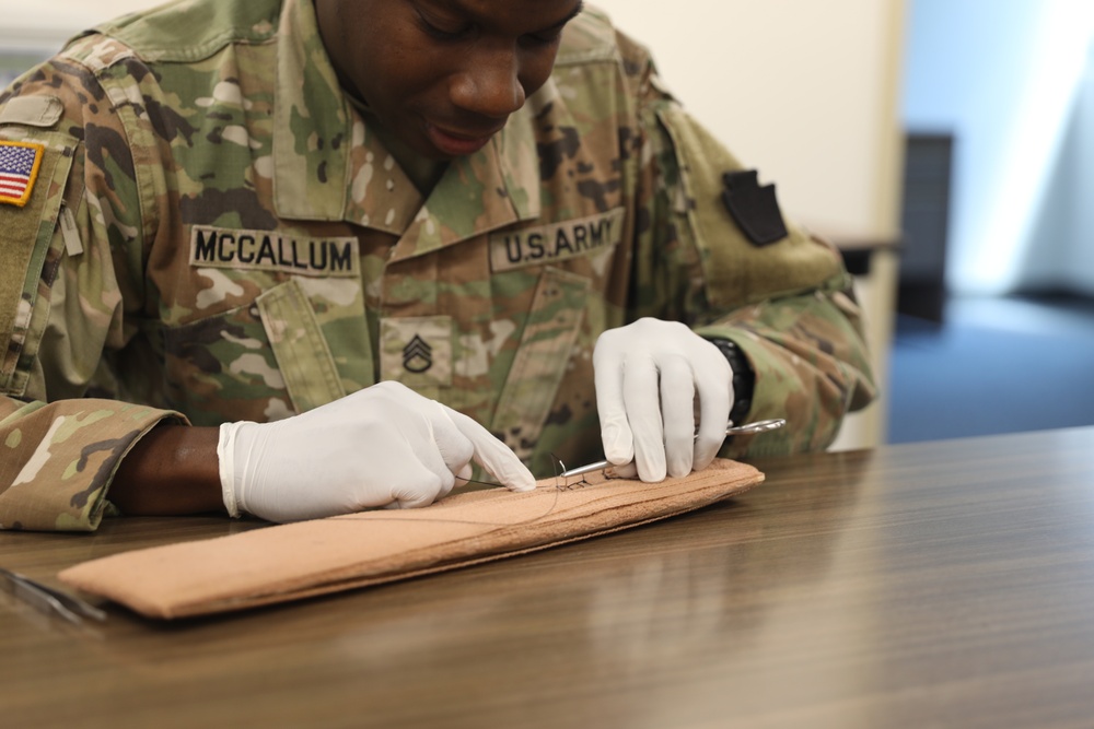 Army medic practices suturing