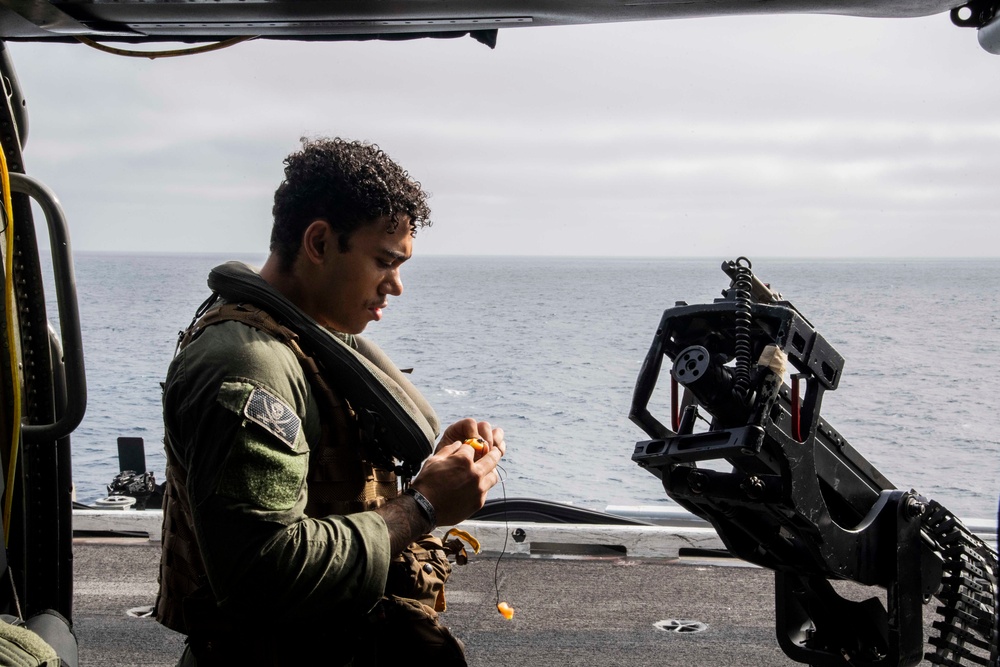 Sailors assigned to (HSC) 4 prepare for flight in an MH-60S Sea Hawk