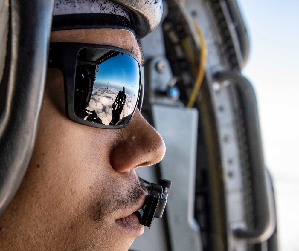 A Naval Air Crewman (Helicopter) fires an M3 .50 caliber machine gun