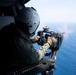 A Naval Air Crewman (Helicopter) fires an M3 .50 caliber machine gun