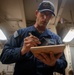 A Nimitz Sailor Applies Coating To Plaque