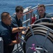 USS Tripoli Sailors spray and clean AFFF off of the Flight deck