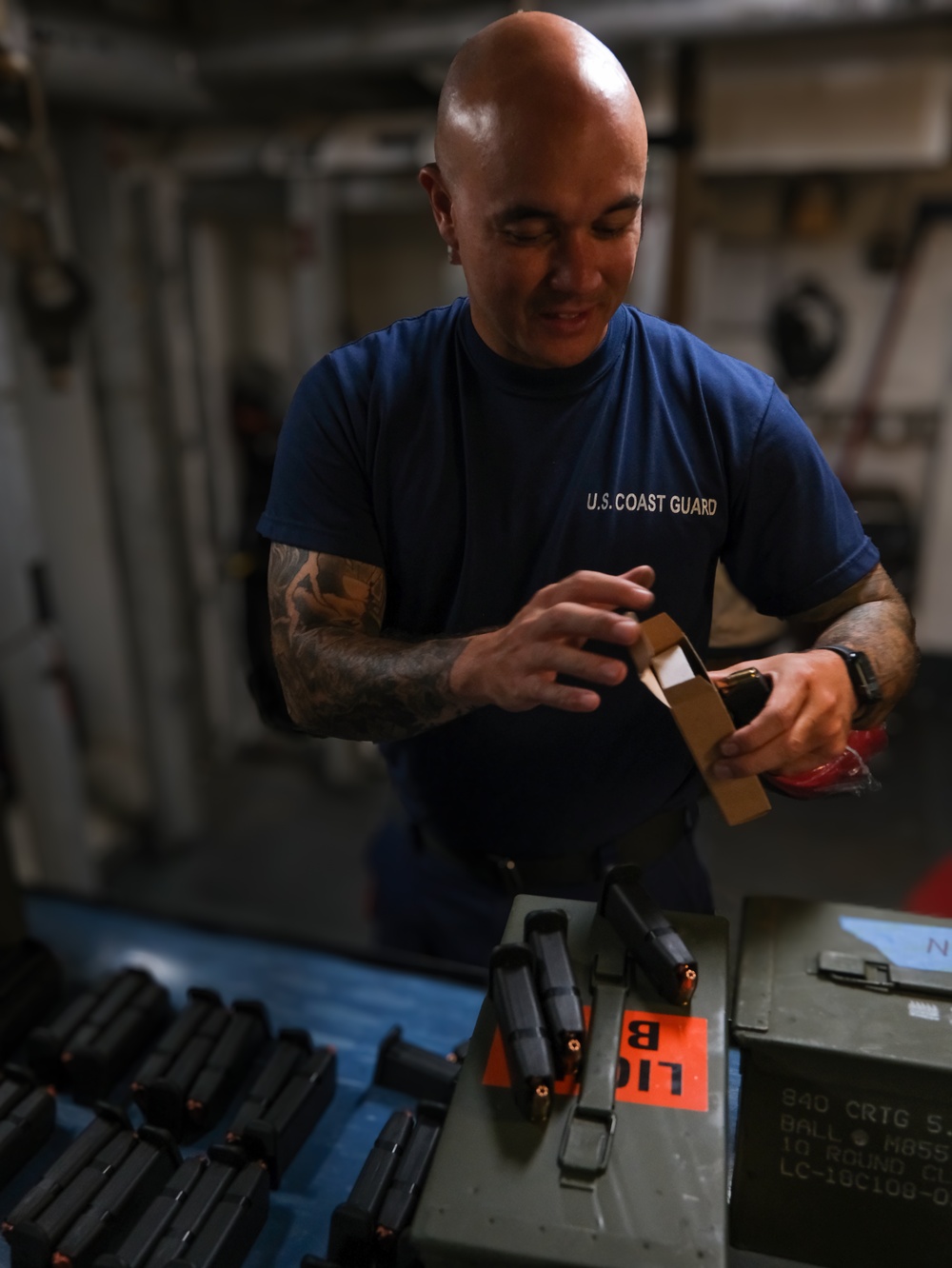 Coast Guard Cutter Northland crew members organize firearms in the armory