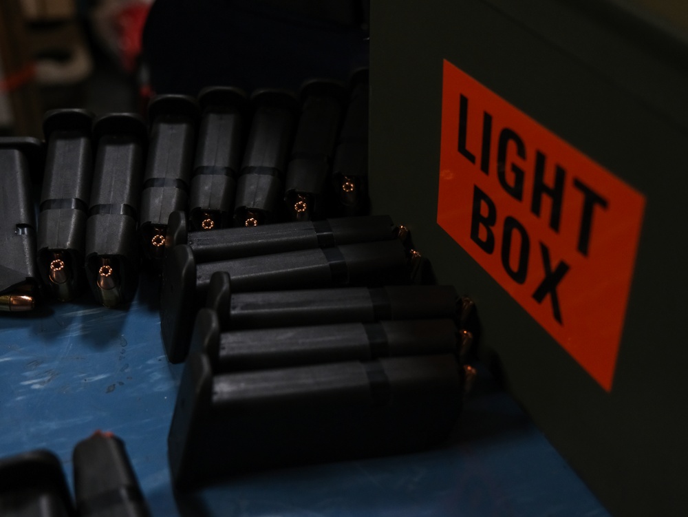 Coast Guard Cutter Northland crew members organize firearms in the armory