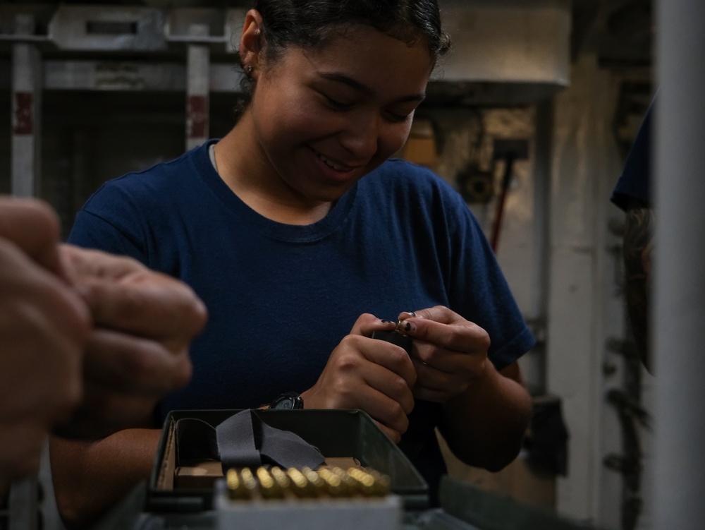 Coast Guard Cutter Northland crew members organize firearms in the armory