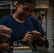 Coast Guard Cutter Northland crew members organize firearms in the armory