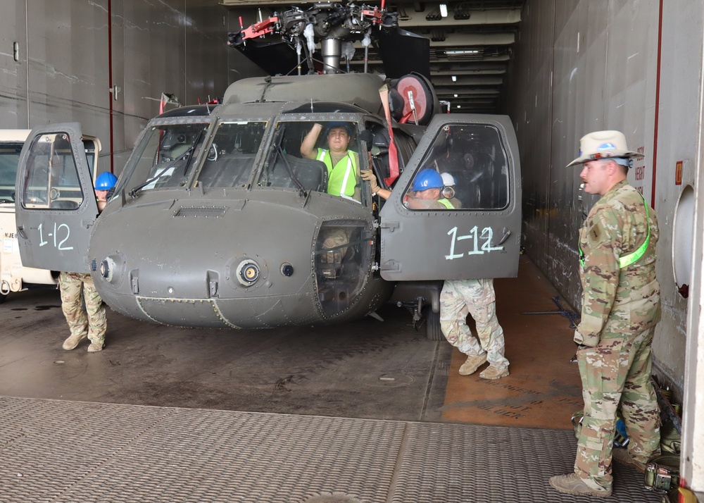 Soldiers assigned to the 1st Infantry Division Combat Aviation Brigade (CAB) unload their aircraft from aboard a commercial cargo vessel at the Port of Corpus Christi, Texas, Aug. 13.