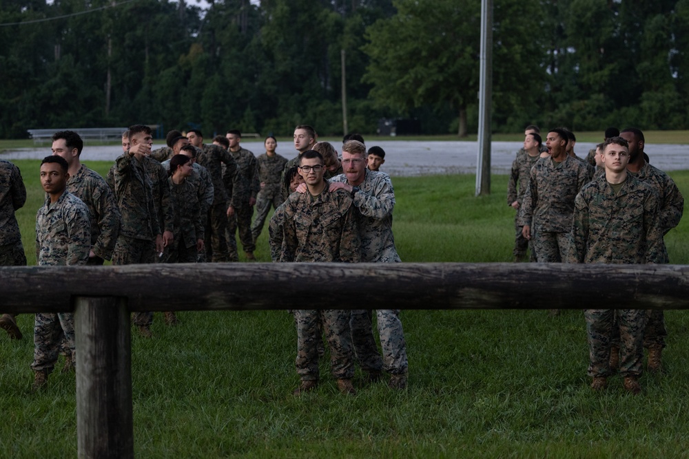 Marines with Marine Corps Combat Service Support Schools maneuver through an obstacle course