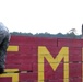 Marines with Marine Corps Combat Service Support Schools maneuver through an obstacle course