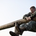 Marines with Marine Corps Combat Service Support Schools maneuver through an obstacle course