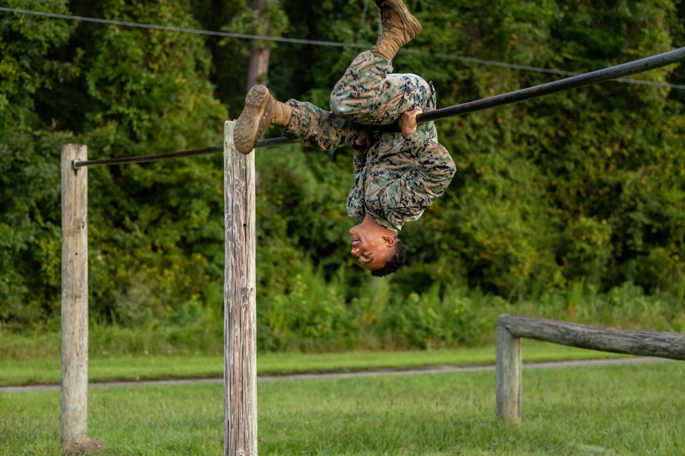 Marines with Marine Corps Combat Service Support Schools maneuver through an obstacle course