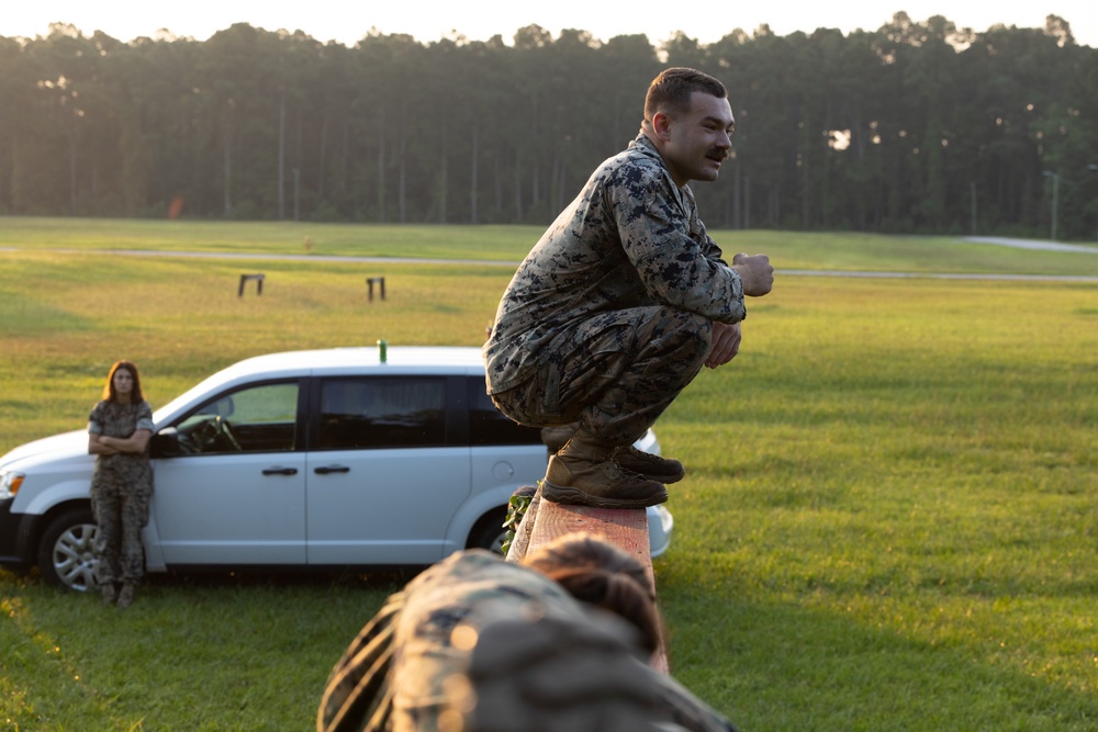 Marines with Marine Corps Combat Service Support Schools maneuver through an obstacle course