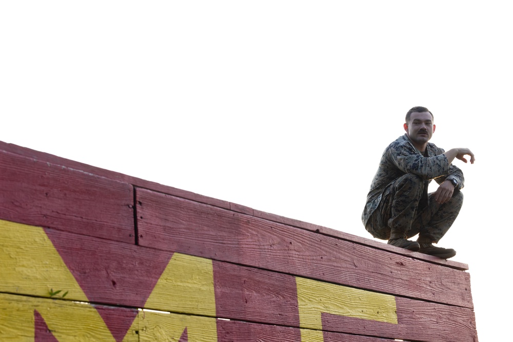 Marines with Marine Corps Combat Service Support Schools maneuver through an obstacle course