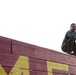 Marines with Marine Corps Combat Service Support Schools maneuver through an obstacle course