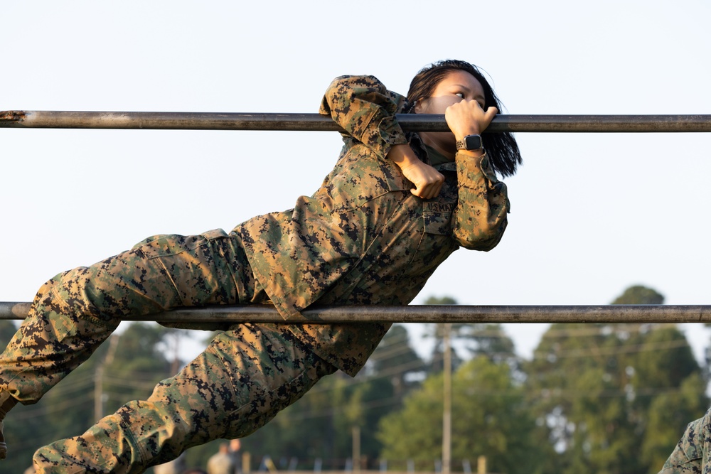 Marines with Marine Corps Combat Service Support Schools maneuver through an obstacle course