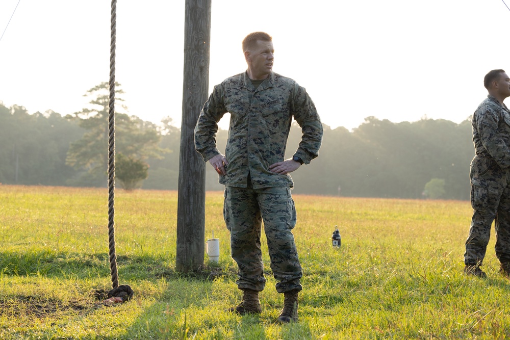 Marines with Marine Corps Combat Service Support Schools maneuver through an obstacle course