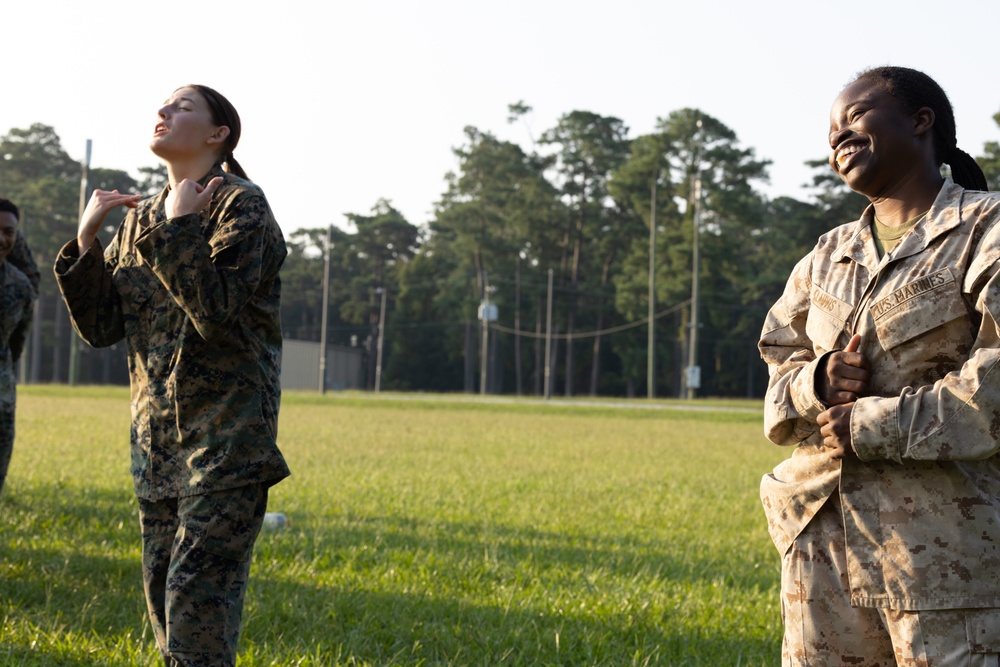 Marines with Marine Corps Combat Service Support Schools maneuver through an obstacle course